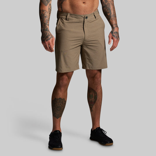 Man wearing beige shorts on a gray background
