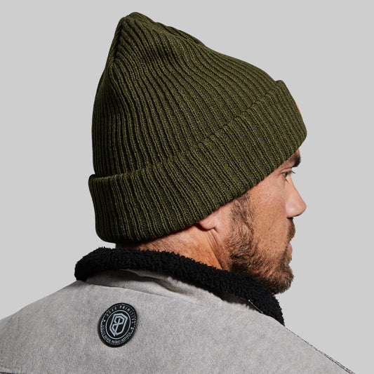 Man wearing a green beanie on a gray background
