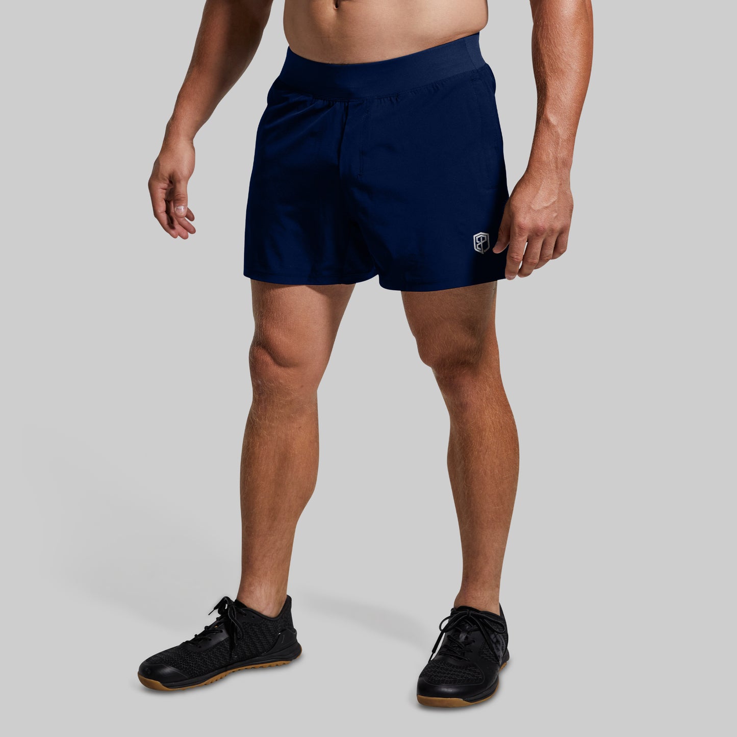 Person wearing navy shorts on a plain background