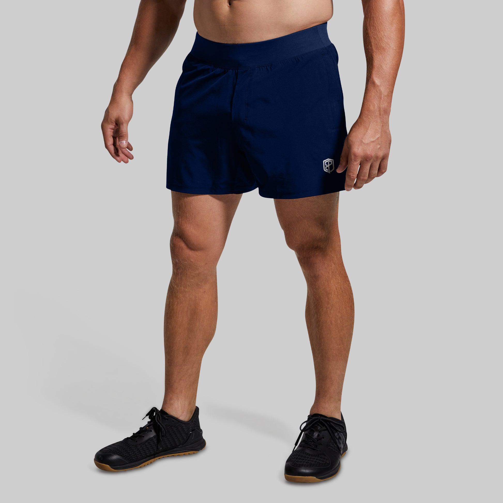 Person wearing navy shorts on a plain background