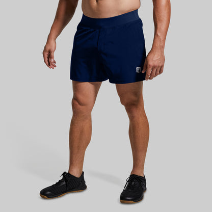 Person wearing navy shorts on a plain background