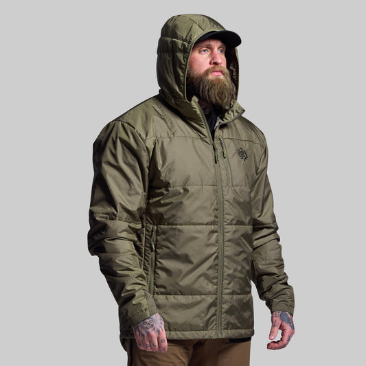 Man wearing a green hooded jacket on a gray background