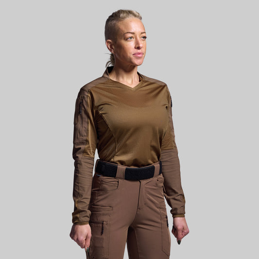 Person wearing a brown tactical outfit on a gray background