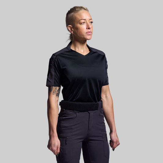 Person wearing a black tactical outfit on a gray background