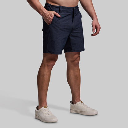 Person wearing navy shorts on a plain background