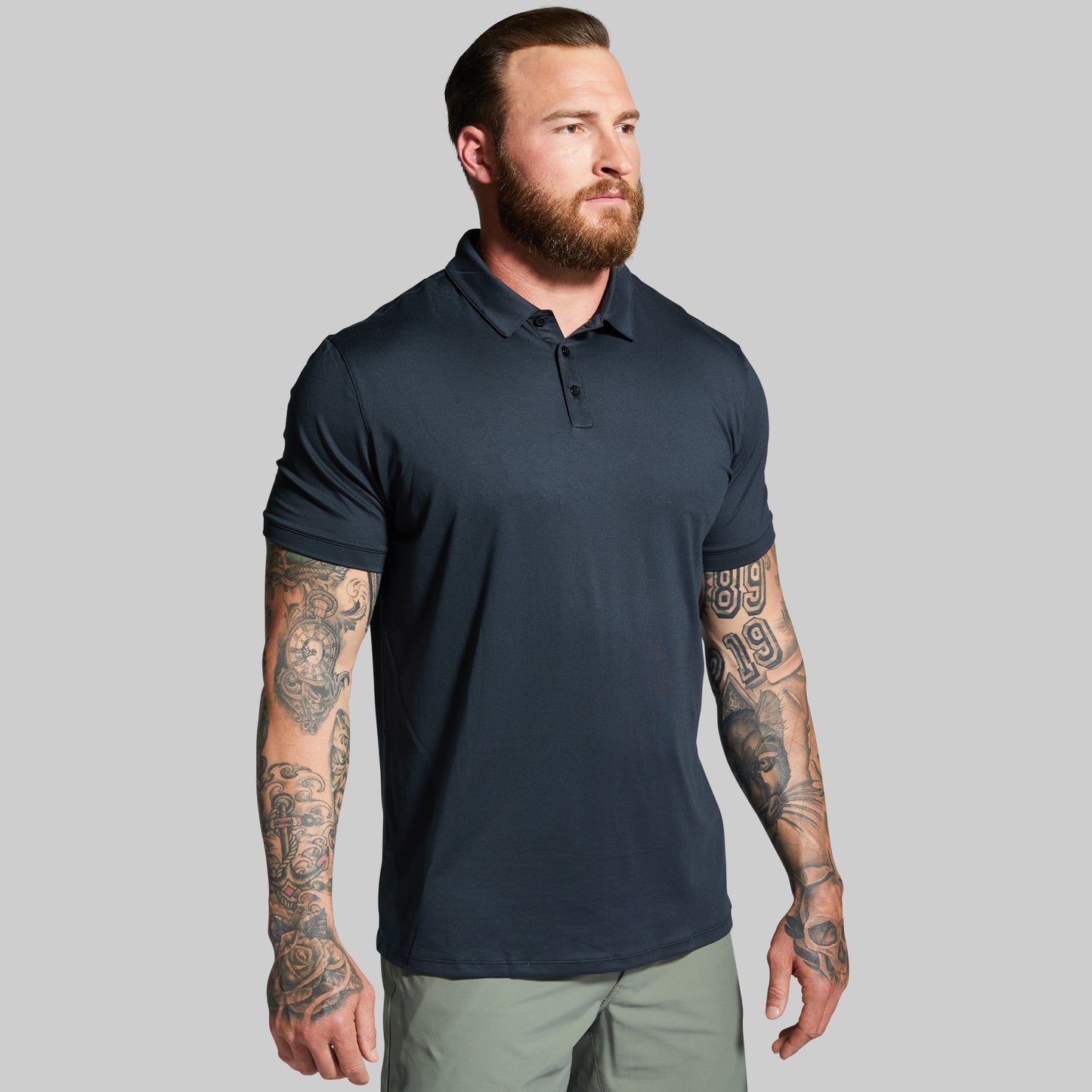 Man wearing a black polo shirt on a gray background
