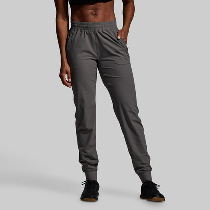 Person wearing gray jogger pants on a plain background