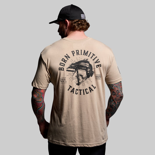 Man wearing a beige t-shirt with 'Born Primitive Tactical' design on the back, against a gray background.