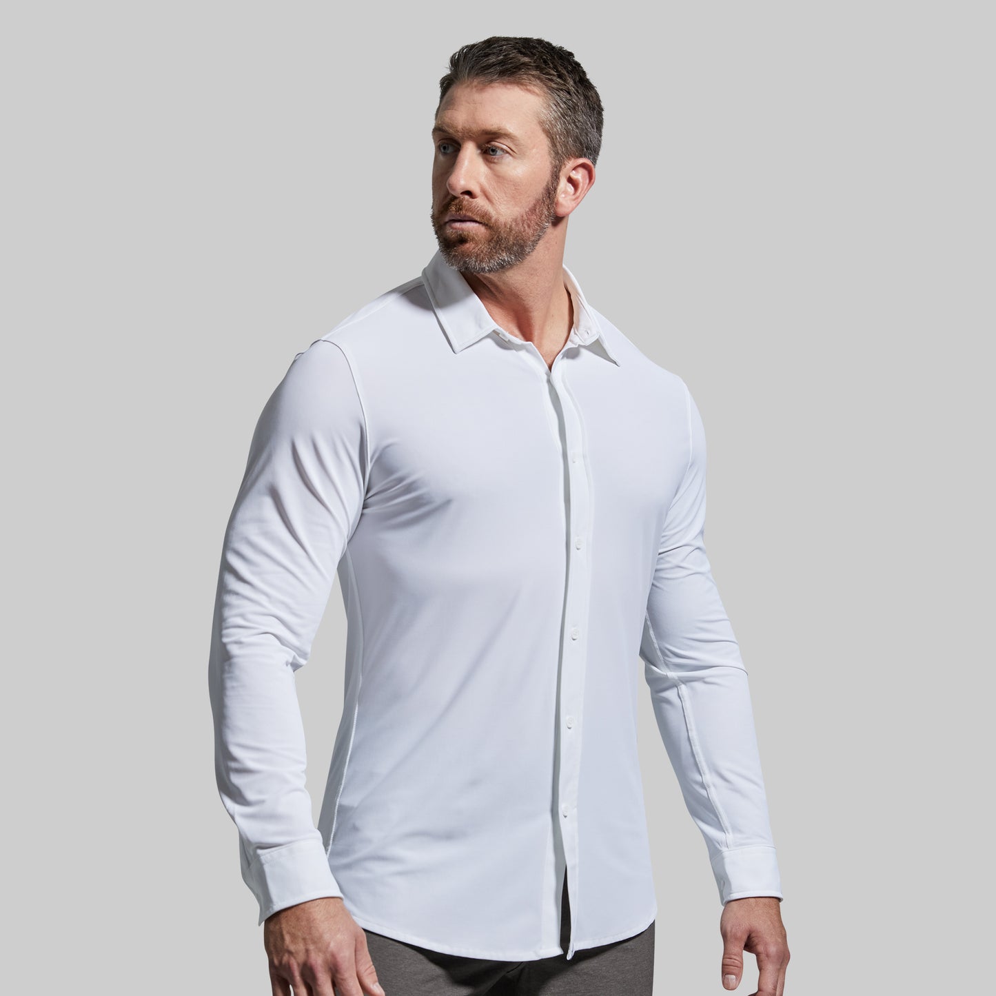 Man wearing a white dress shirt against a gray background