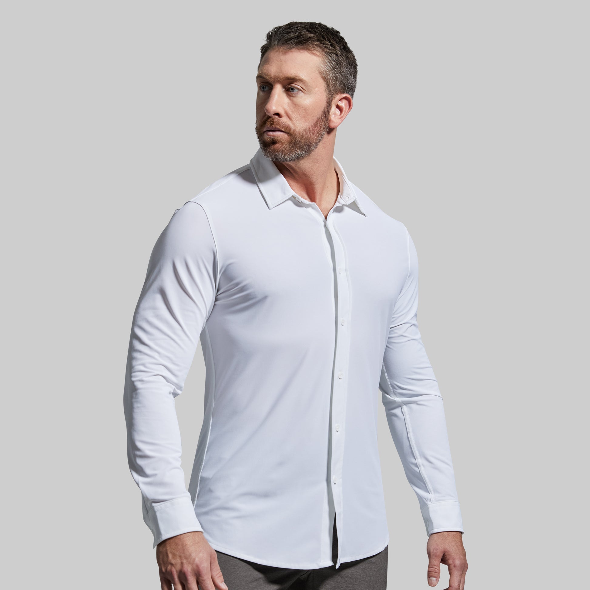 Man wearing a white dress shirt against a gray background