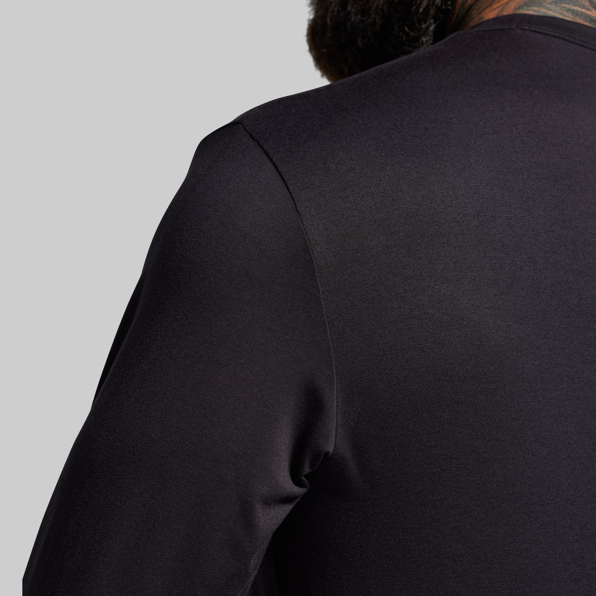 Black long-sleeve shirt on a gray background