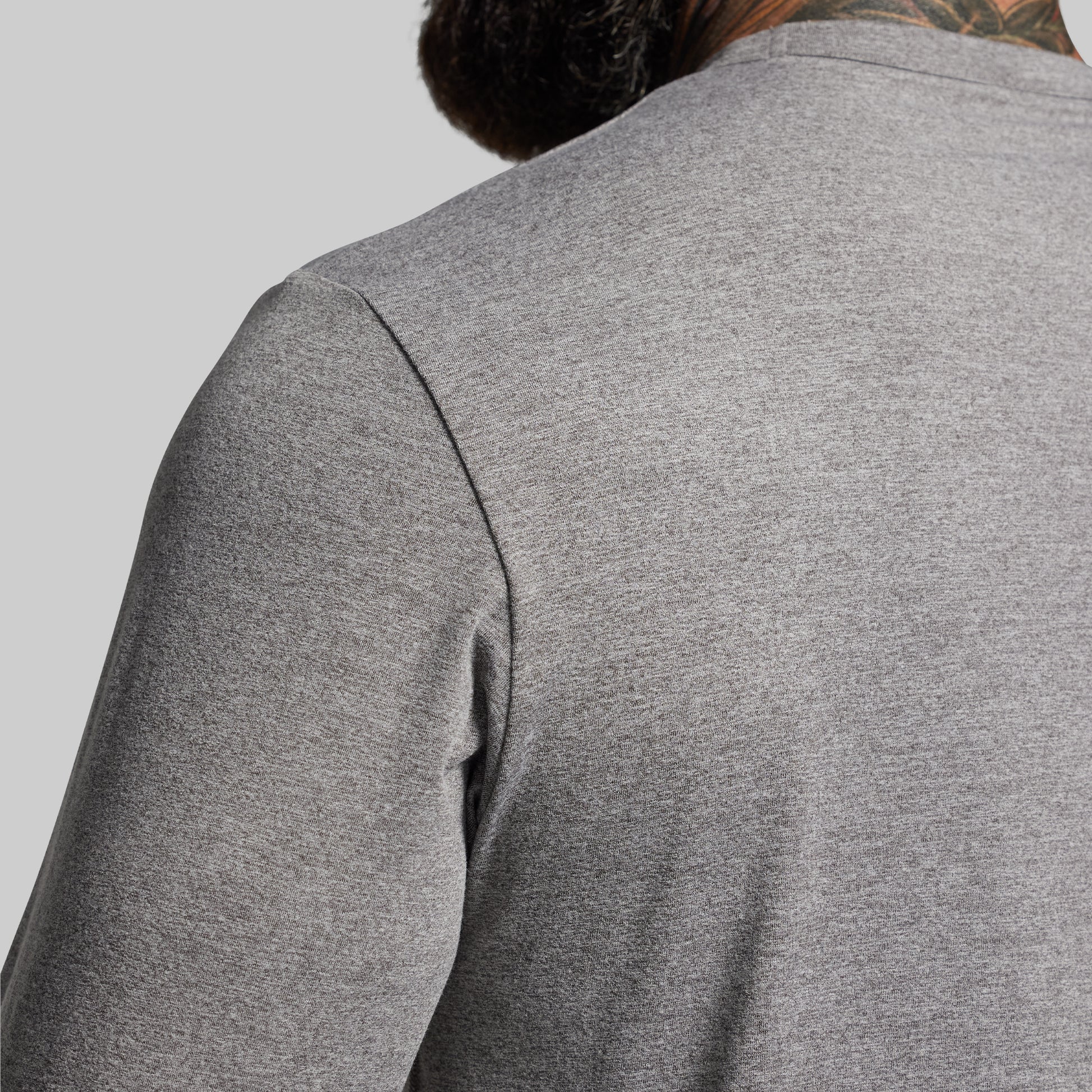 Gray long-sleeve shirt worn by a person on a light gray background
