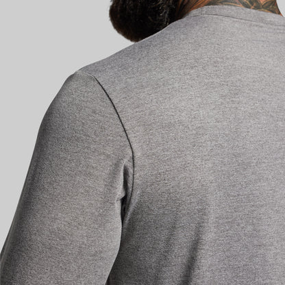 Gray long-sleeve shirt worn by a person on a light gray background