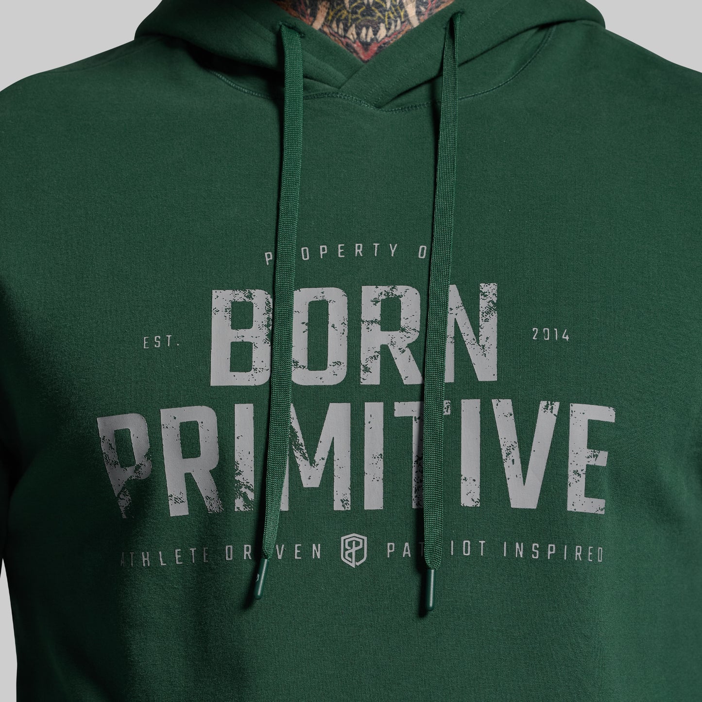 Green hoodie with 'Born Primitive' text on a gray background