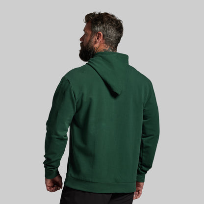 Man wearing a green hoodie from behind on a gray background