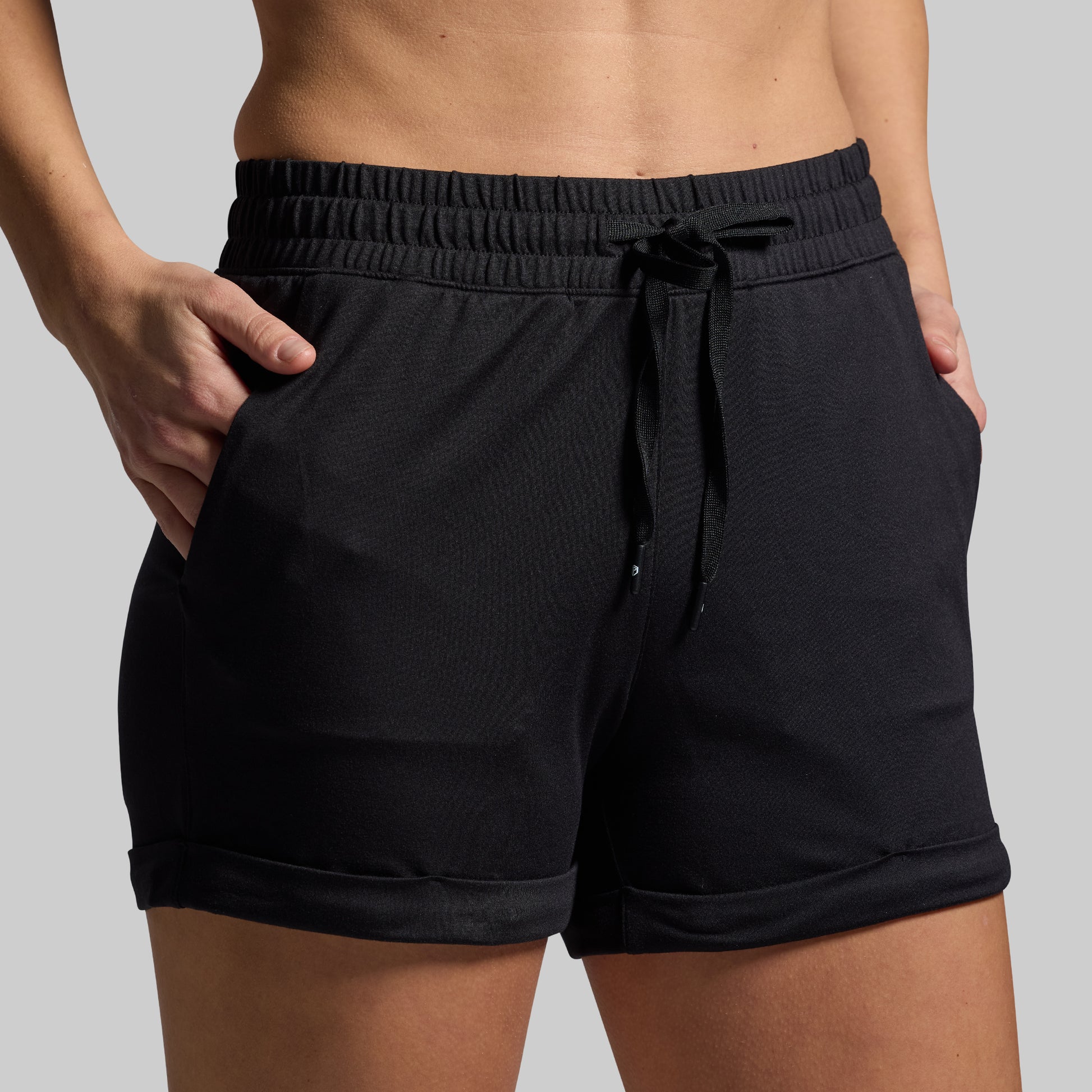 Black shorts with drawstring on a gray background