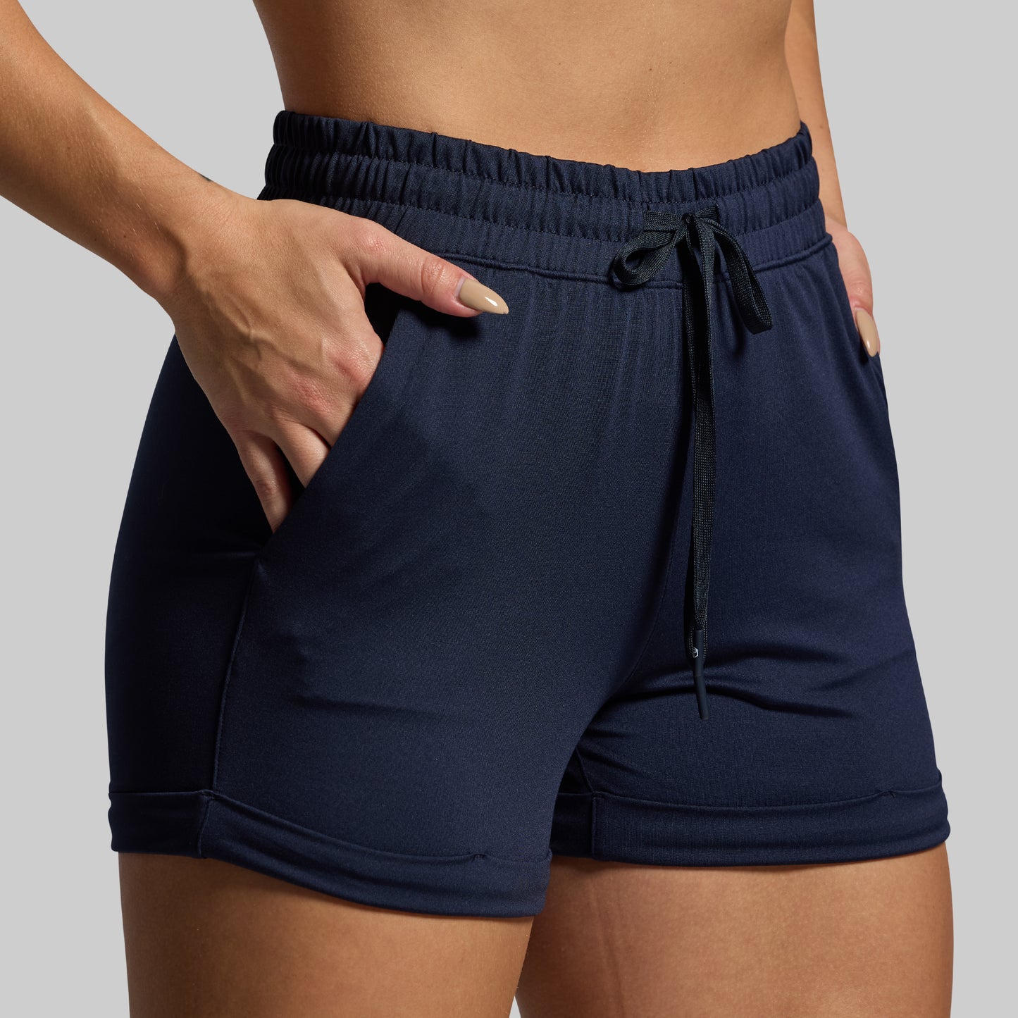 Navy blue shorts with a drawstring on a neutral background