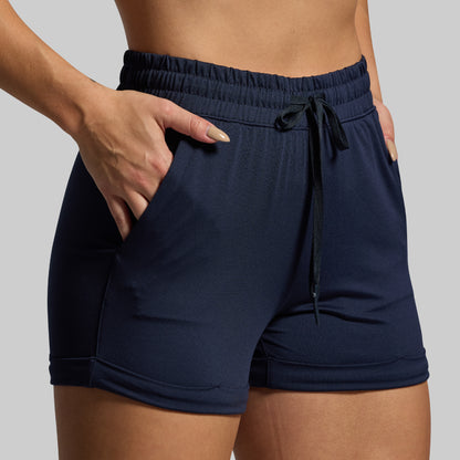 Navy blue shorts with a drawstring on a neutral background