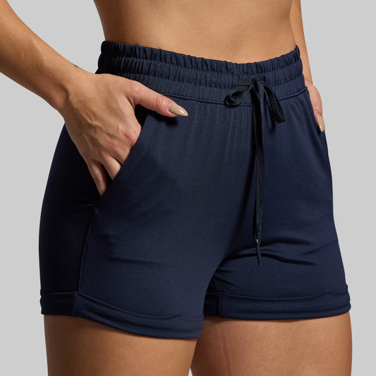 Navy blue shorts with a drawstring on a neutral background