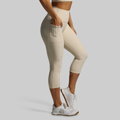 Person wearing beige athletic leggings on a plain background