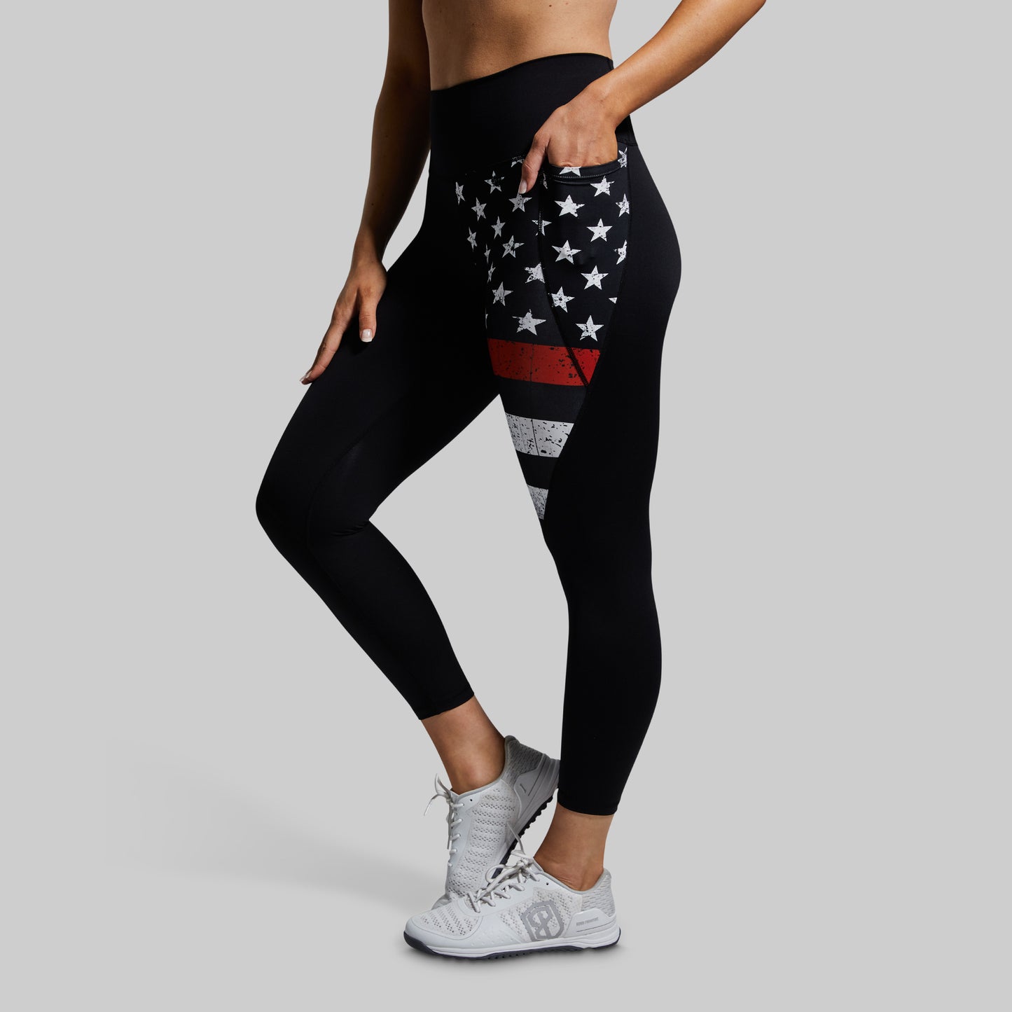 Black leggings with American flag design worn by a person on a gray background
