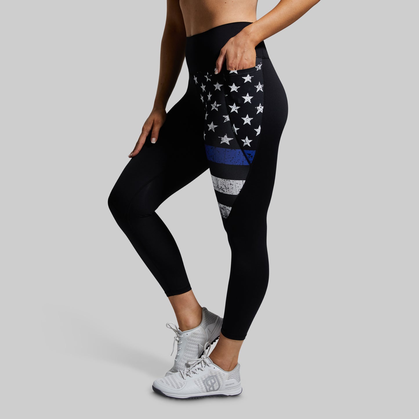 Black leggings with a blue stripe and white stars on a gray background