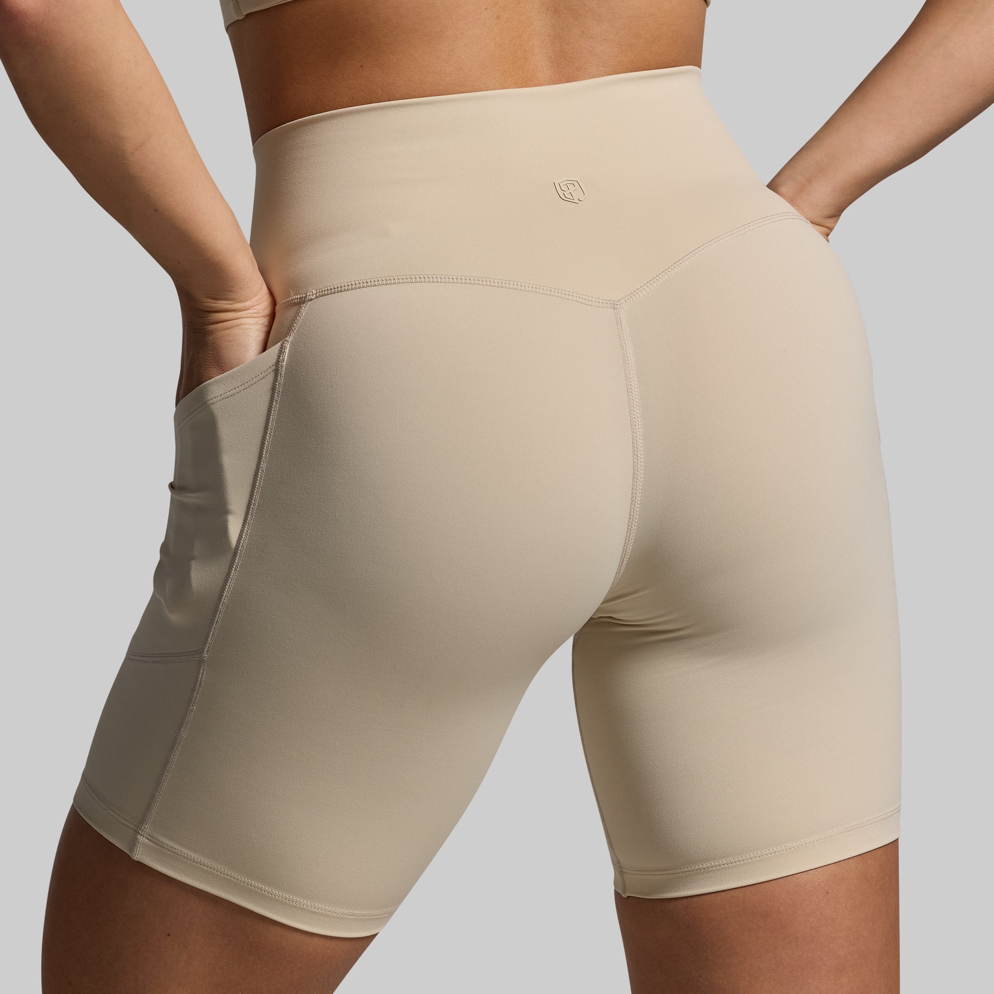 Beige athletic shorts worn by a person on a plain background
