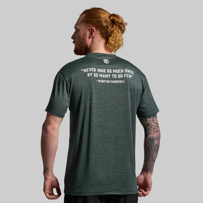 Man wearing a green t-shirt with a quote on the back against a gray background