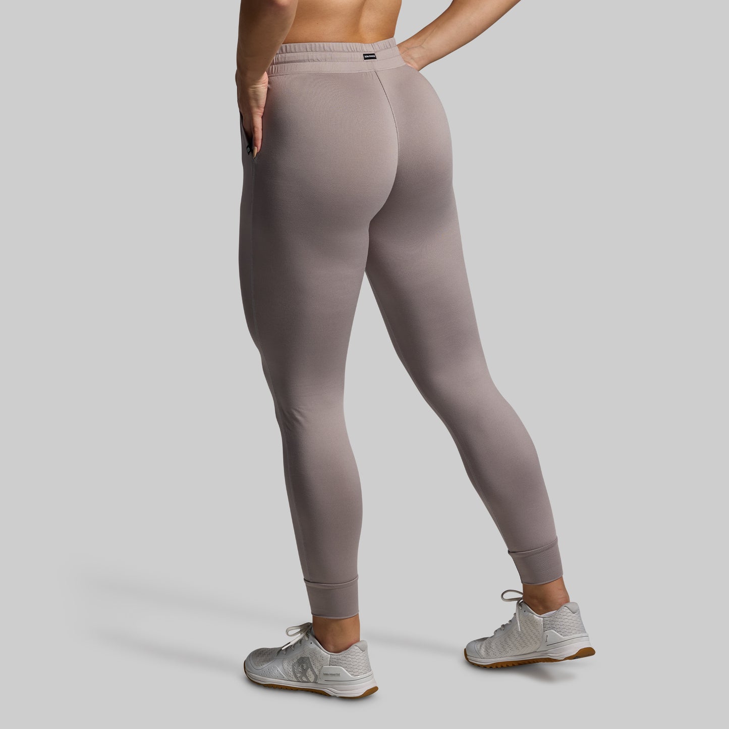 Person wearing gray joggers on a plain background