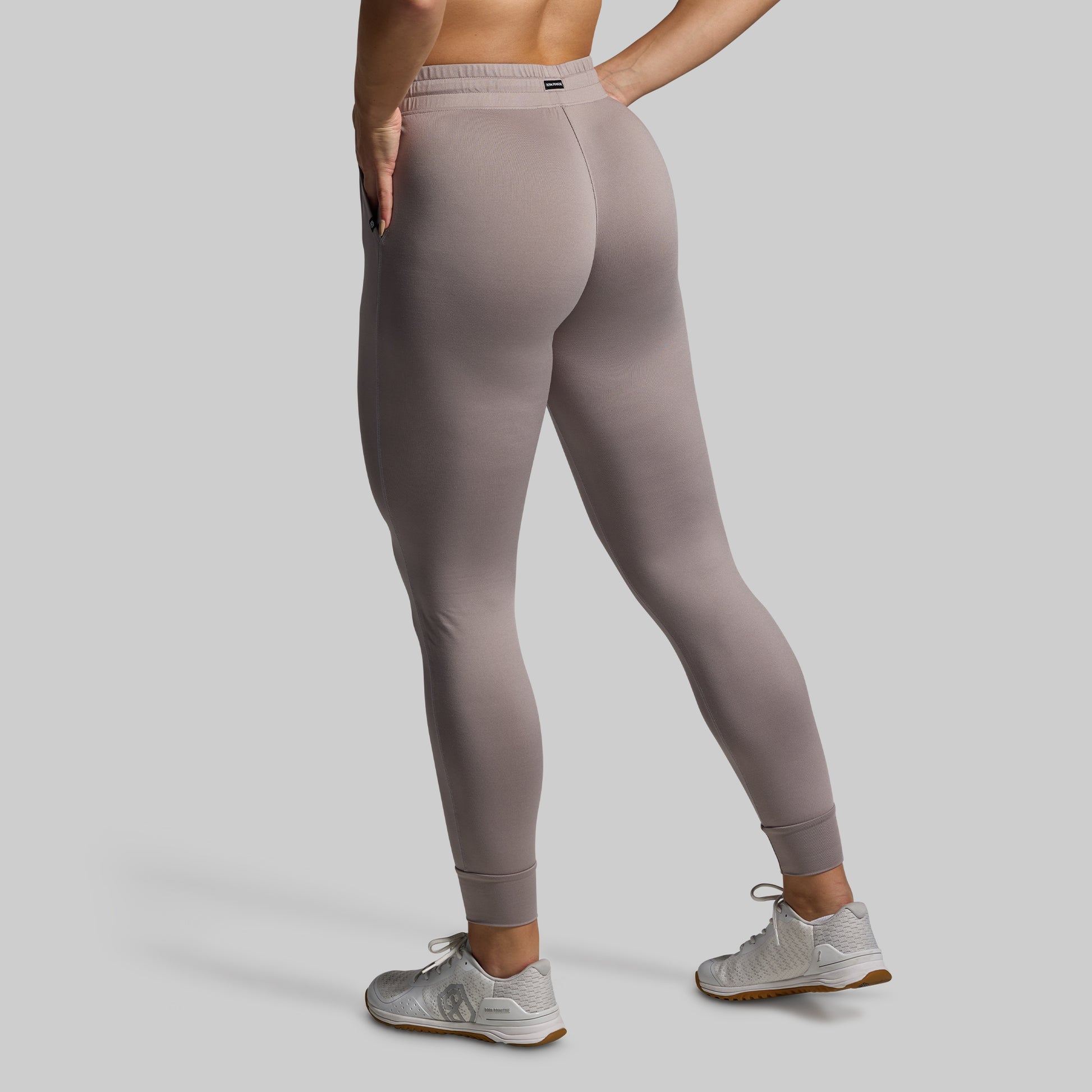Person wearing gray joggers on a plain background