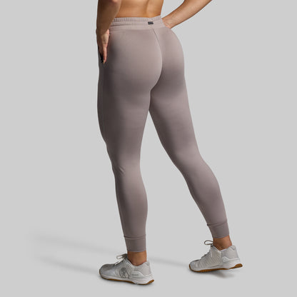 Person wearing gray joggers on a plain background