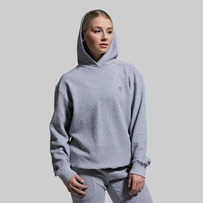 Person wearing a gray hoodie and pants on a plain background
