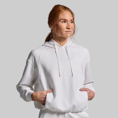 Person wearing a white hoodie against a plain background