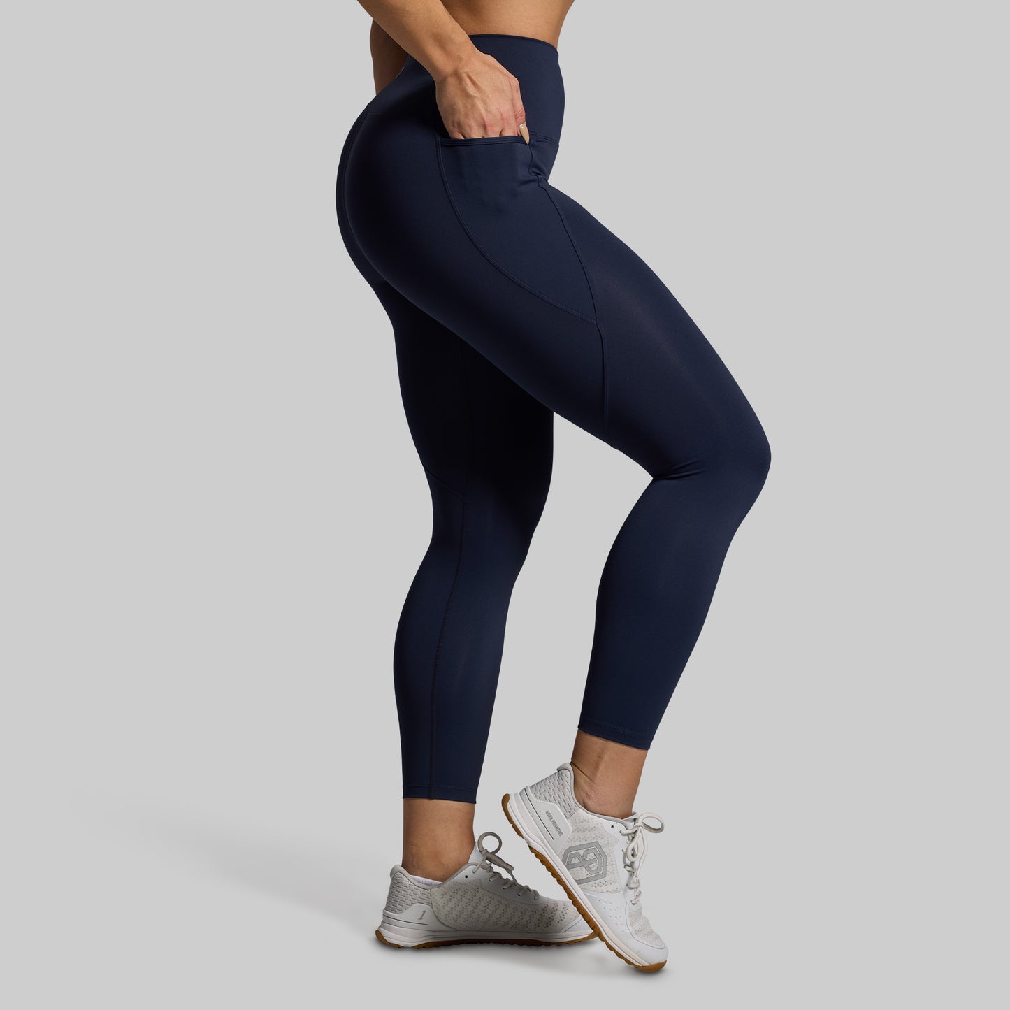Person wearing navy blue leggings with a plain background