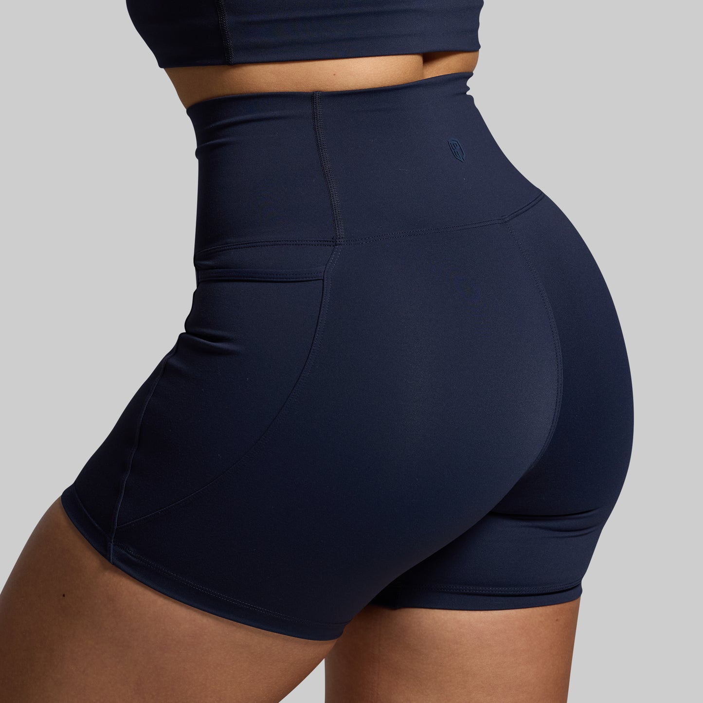 A navy-colored pair of shorts with a high waist, designed for active wear.
