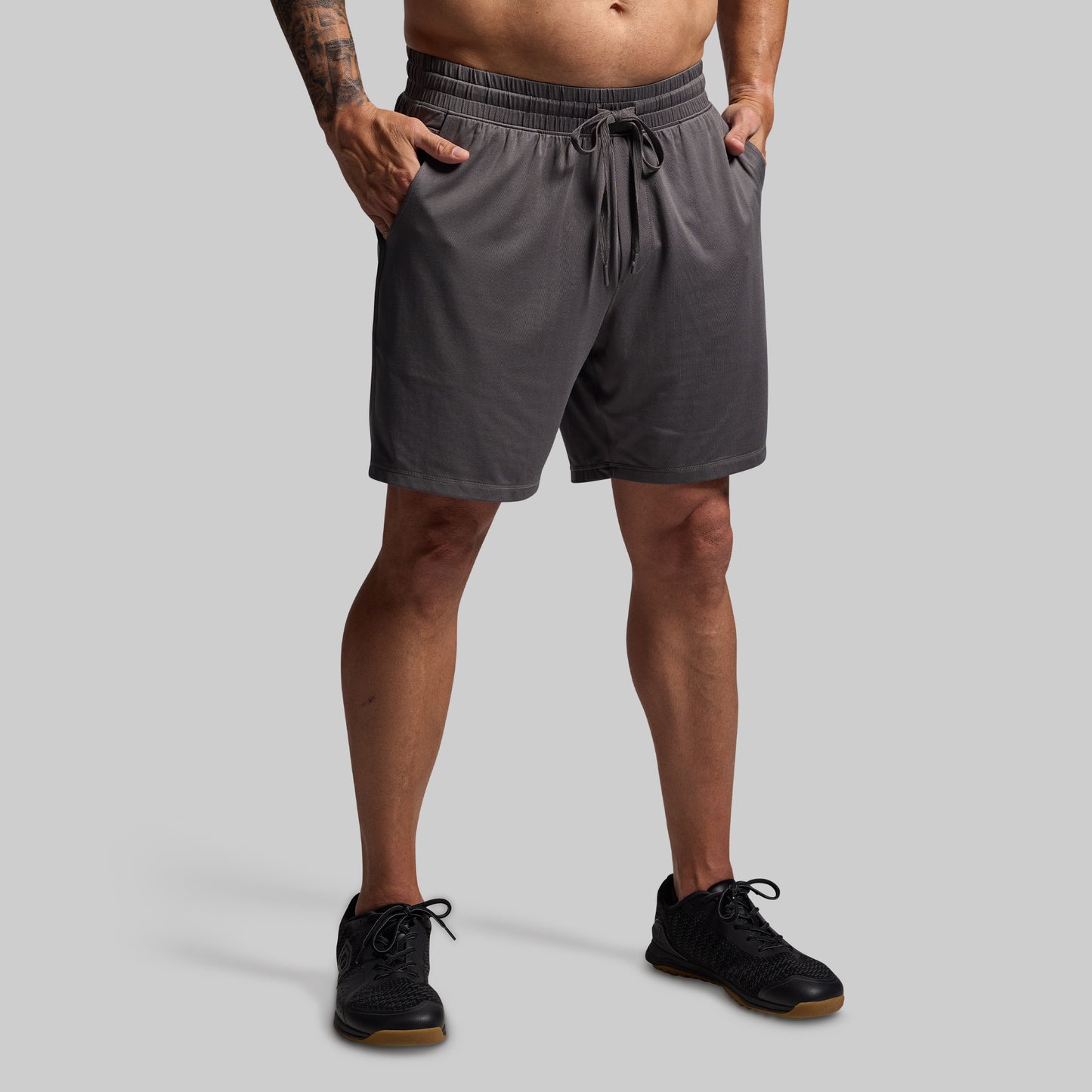 Person wearing gray shorts on a plain background
