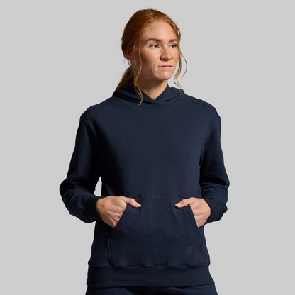 Person wearing a navy blue hoodie on a gray background