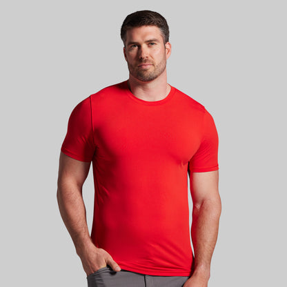 Man wearing a red t-shirt against a gray background