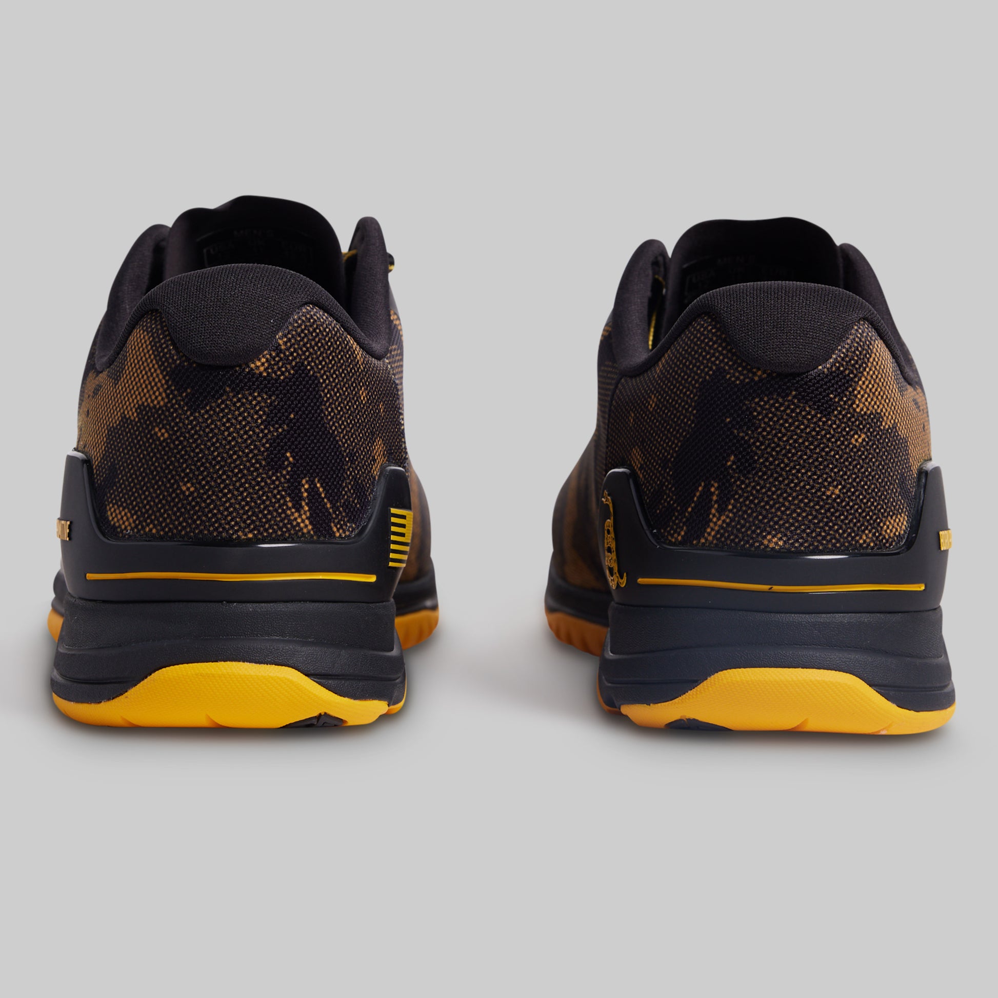 Black and yellow athletic shoes on a gray background