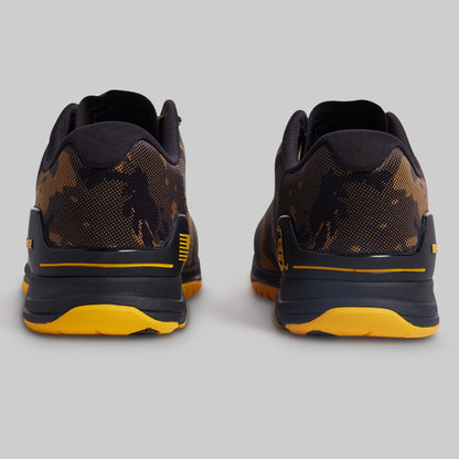 Black and yellow athletic shoes on a gray background