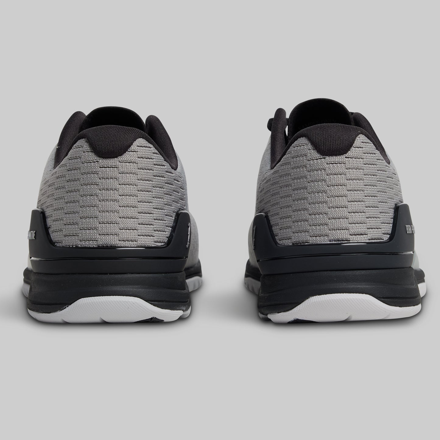 Gray and black athletic shoes on a light gray background