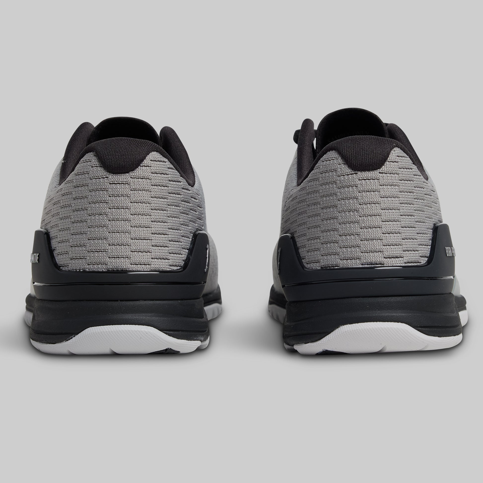 Gray and black athletic shoes on a light gray background