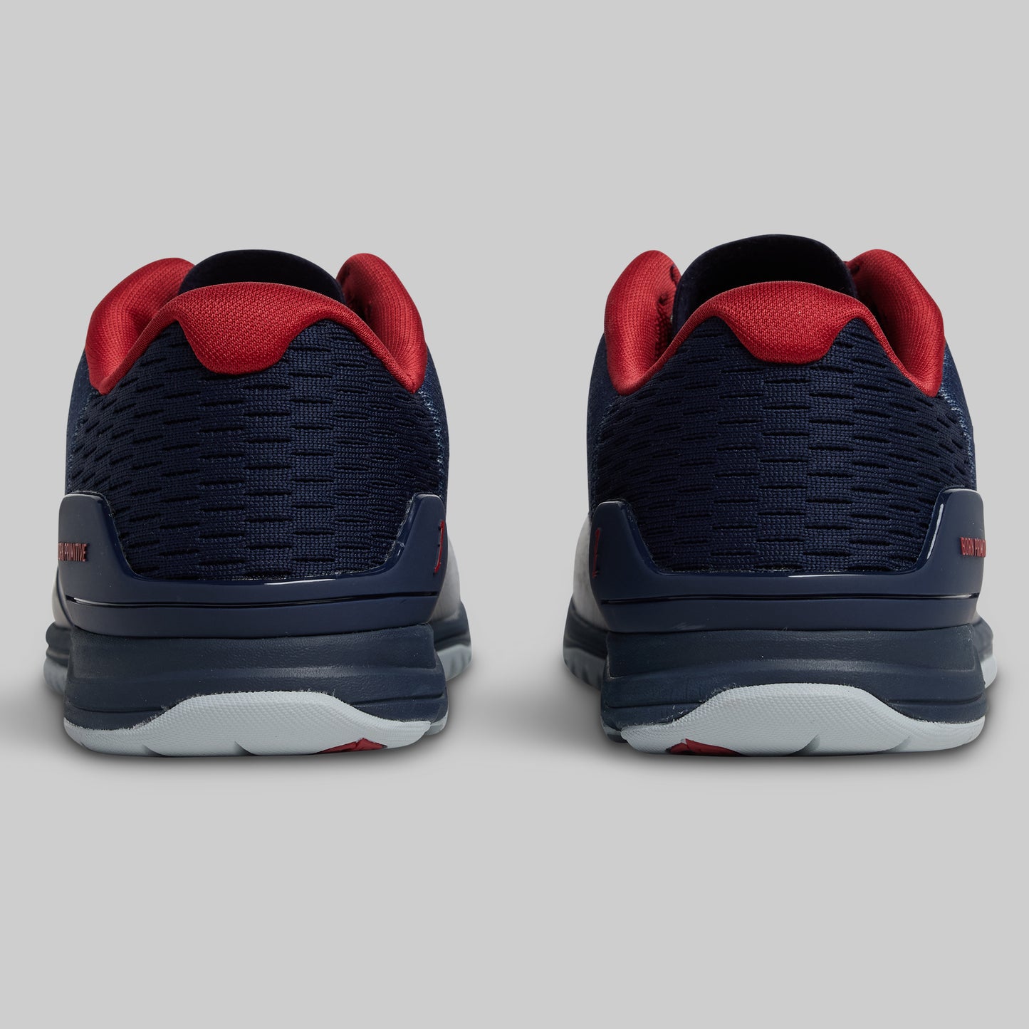 Navy and red athletic shoes on a light gray background