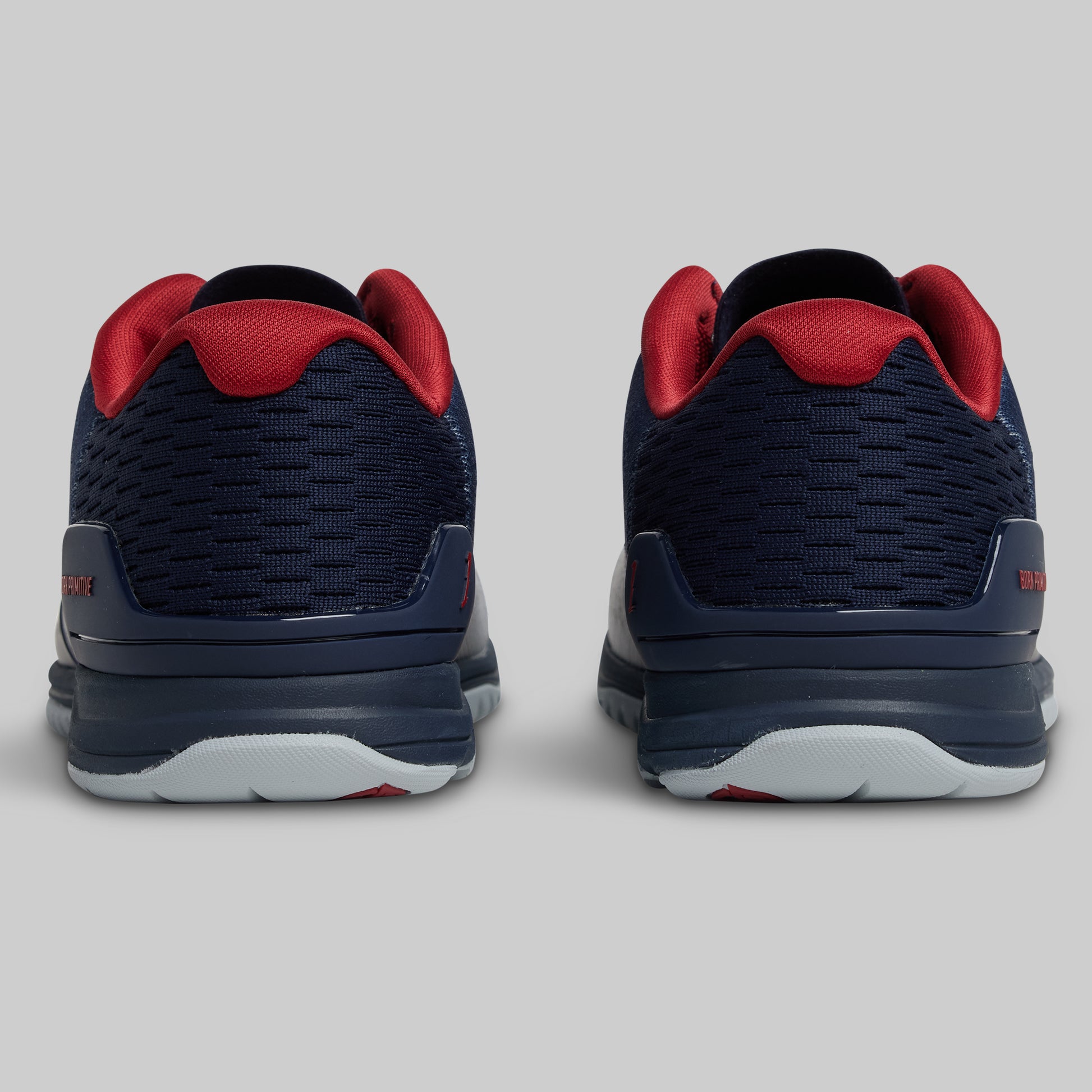 Navy and red athletic shoes on a light gray background