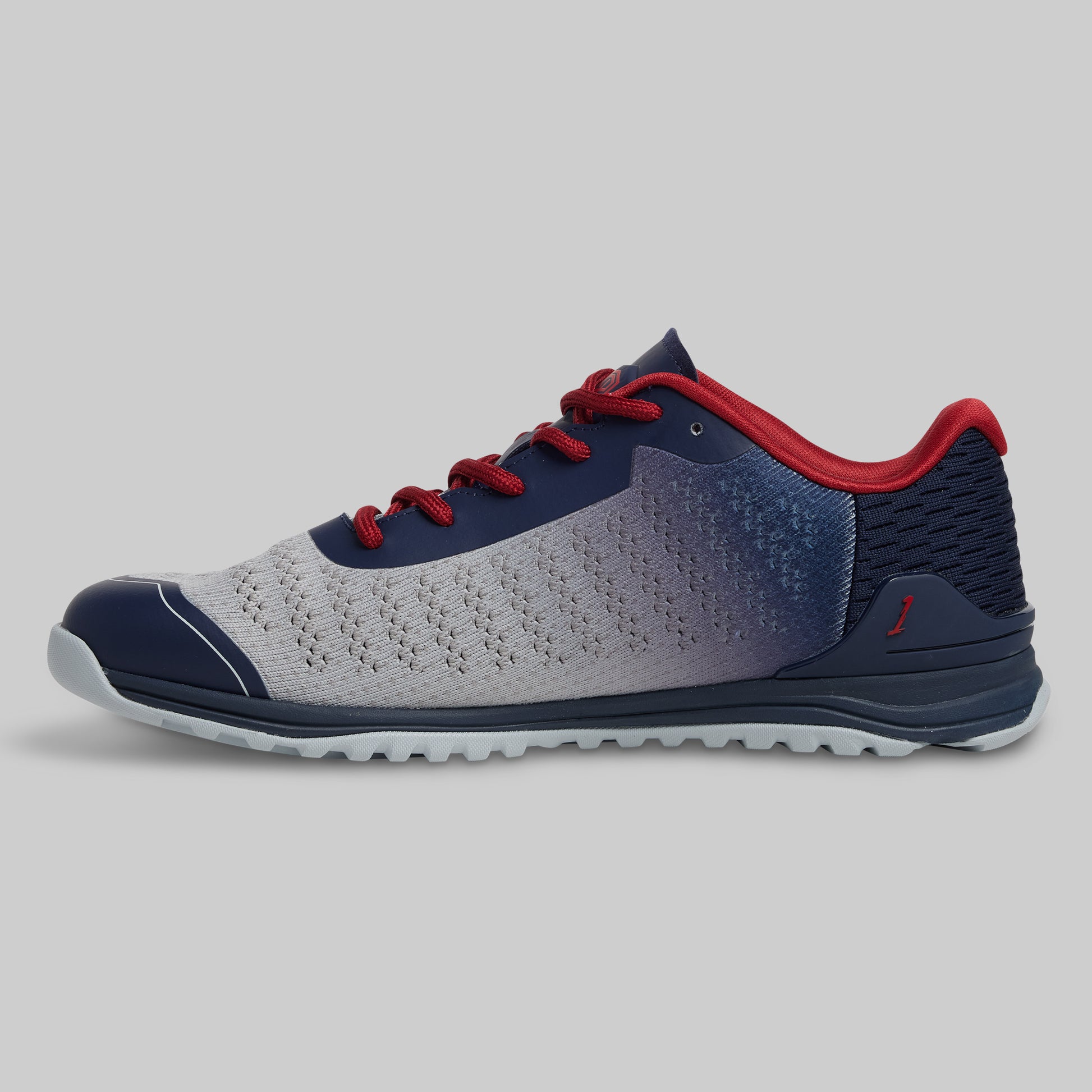 Gray and blue athletic shoe with red accents on a gray background