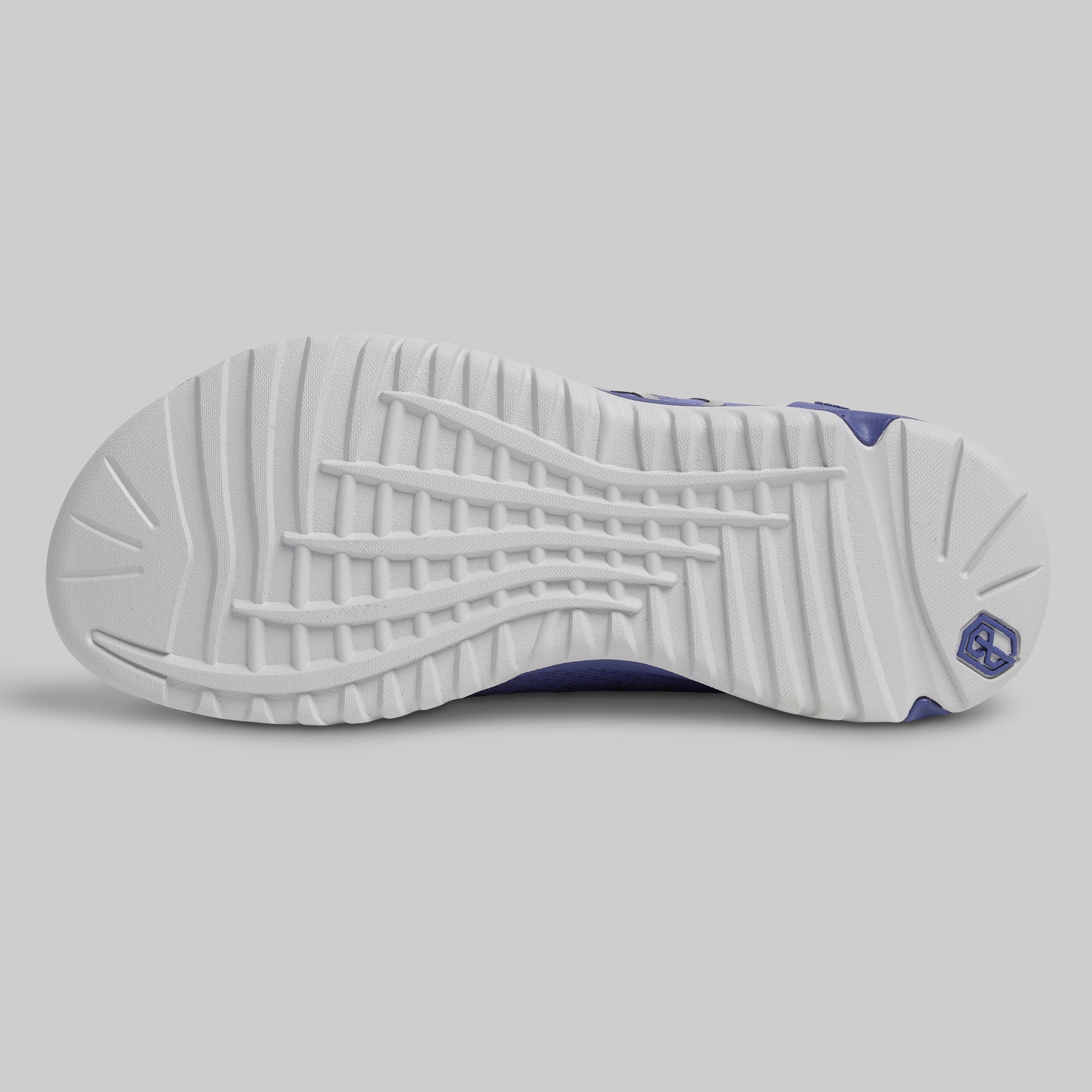 Close-up of a white sneaker sole with purple accents on a light gray background