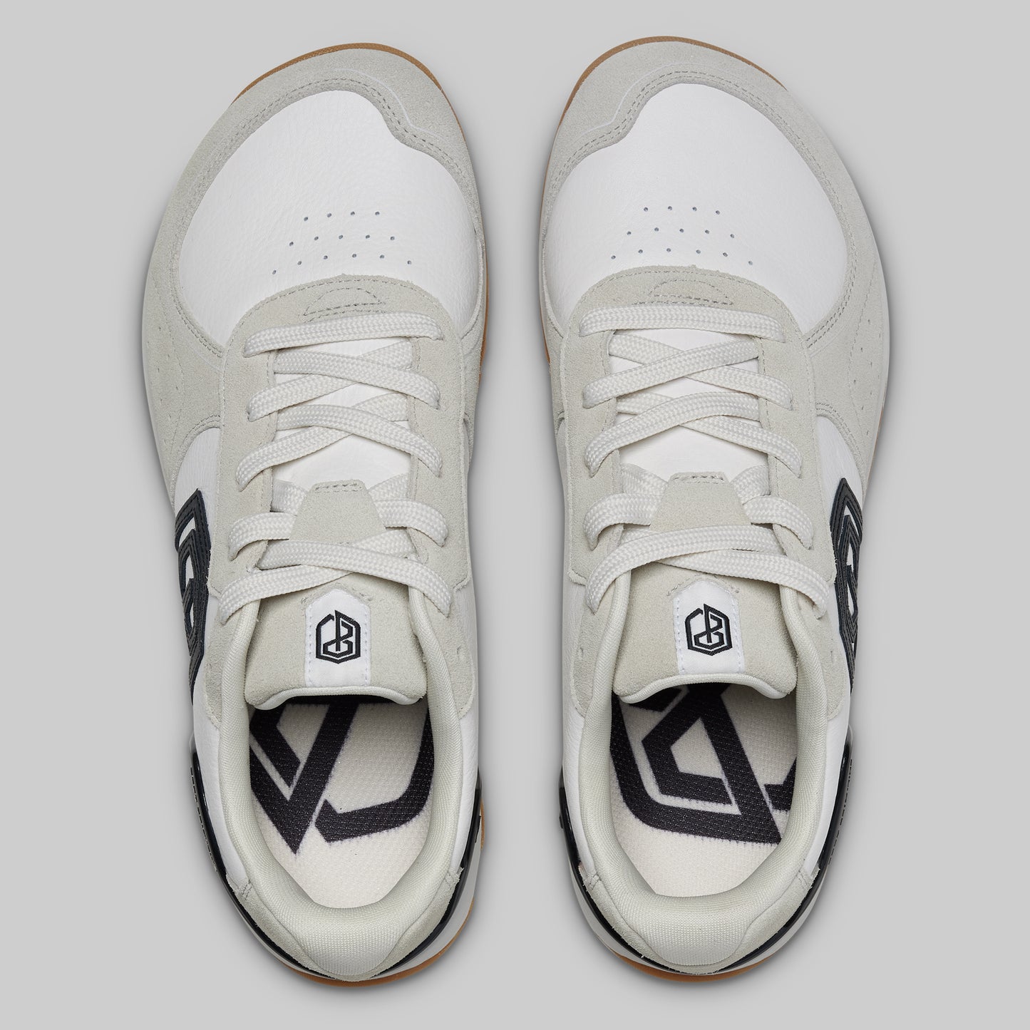 Pair of white sneakers with black accents on a light gray background
