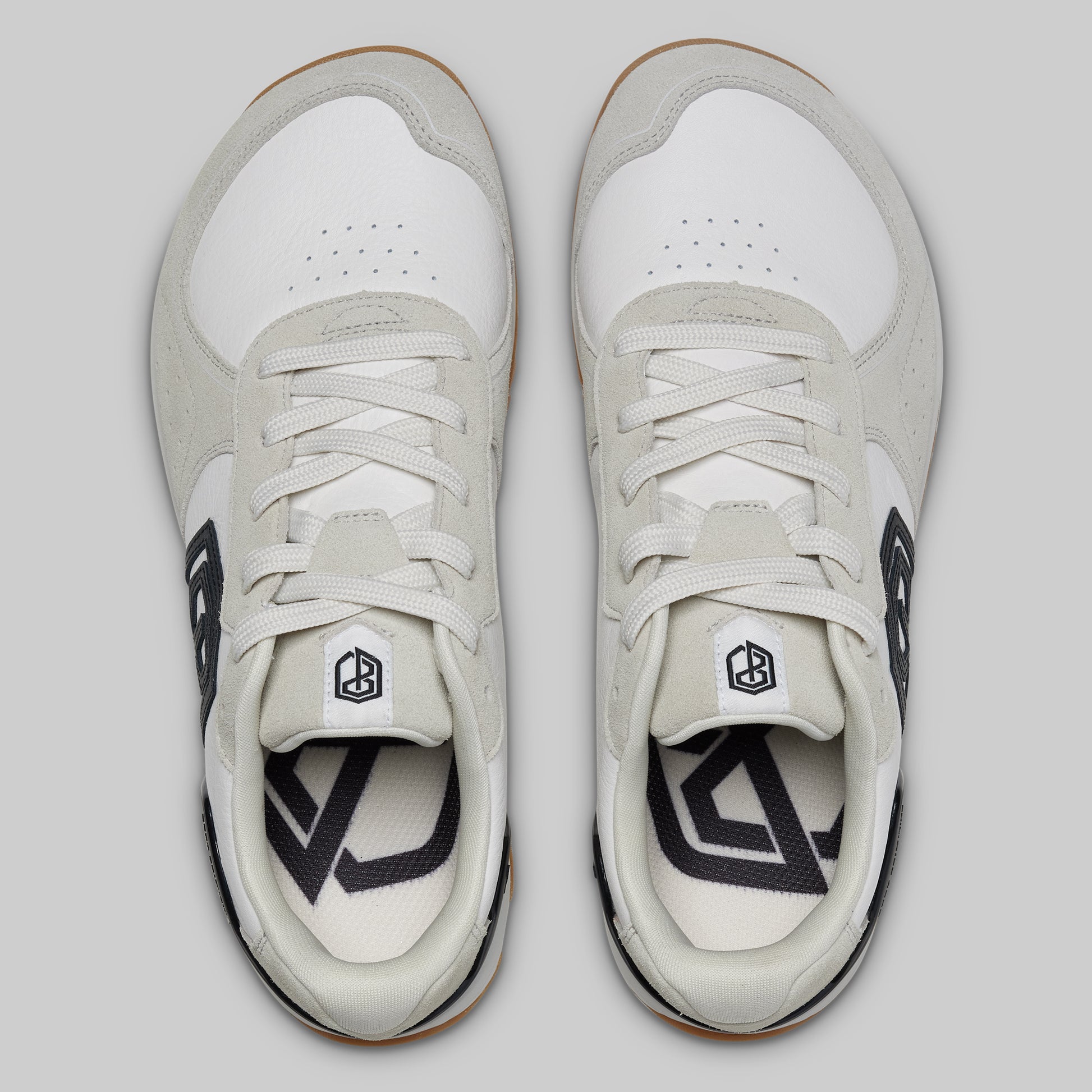 Pair of white sneakers with black accents on a light gray background