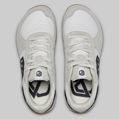 Pair of white sneakers with black accents on a light gray background