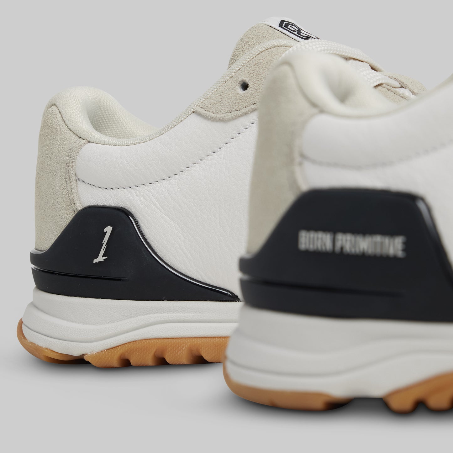 White sneakers with black and brown accents on a light gray background